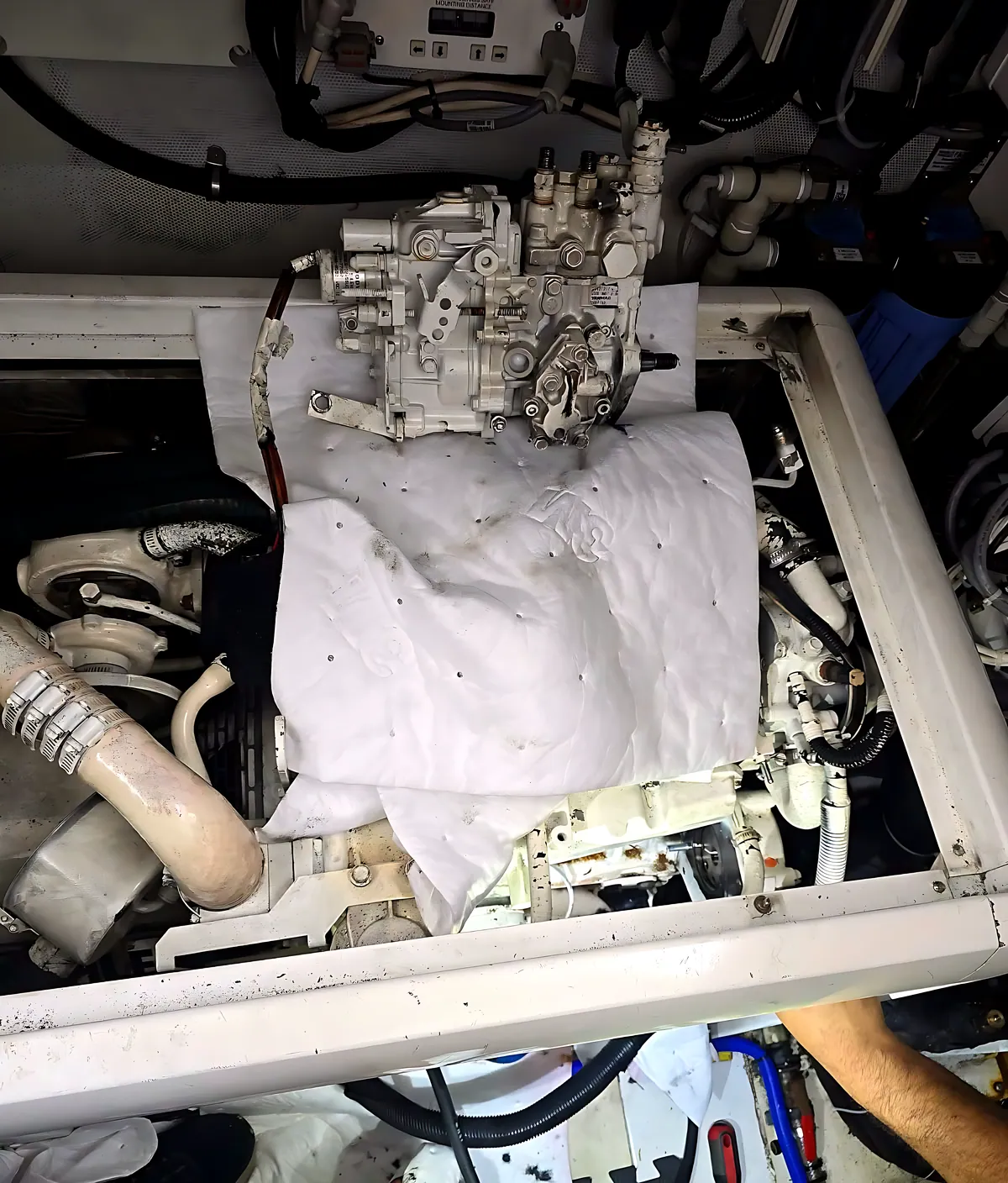 Technician removing a diesel fuel injection pump in a yacht engine room